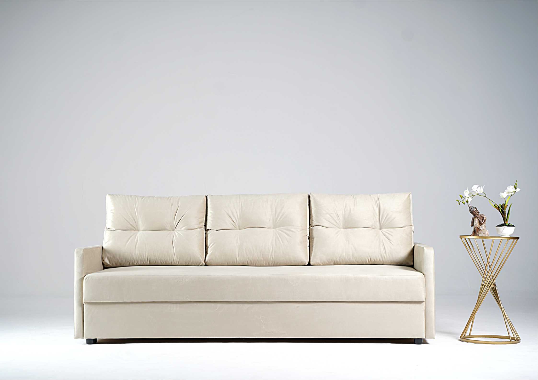 Beżowa sofa z pikowanymi poduszkami